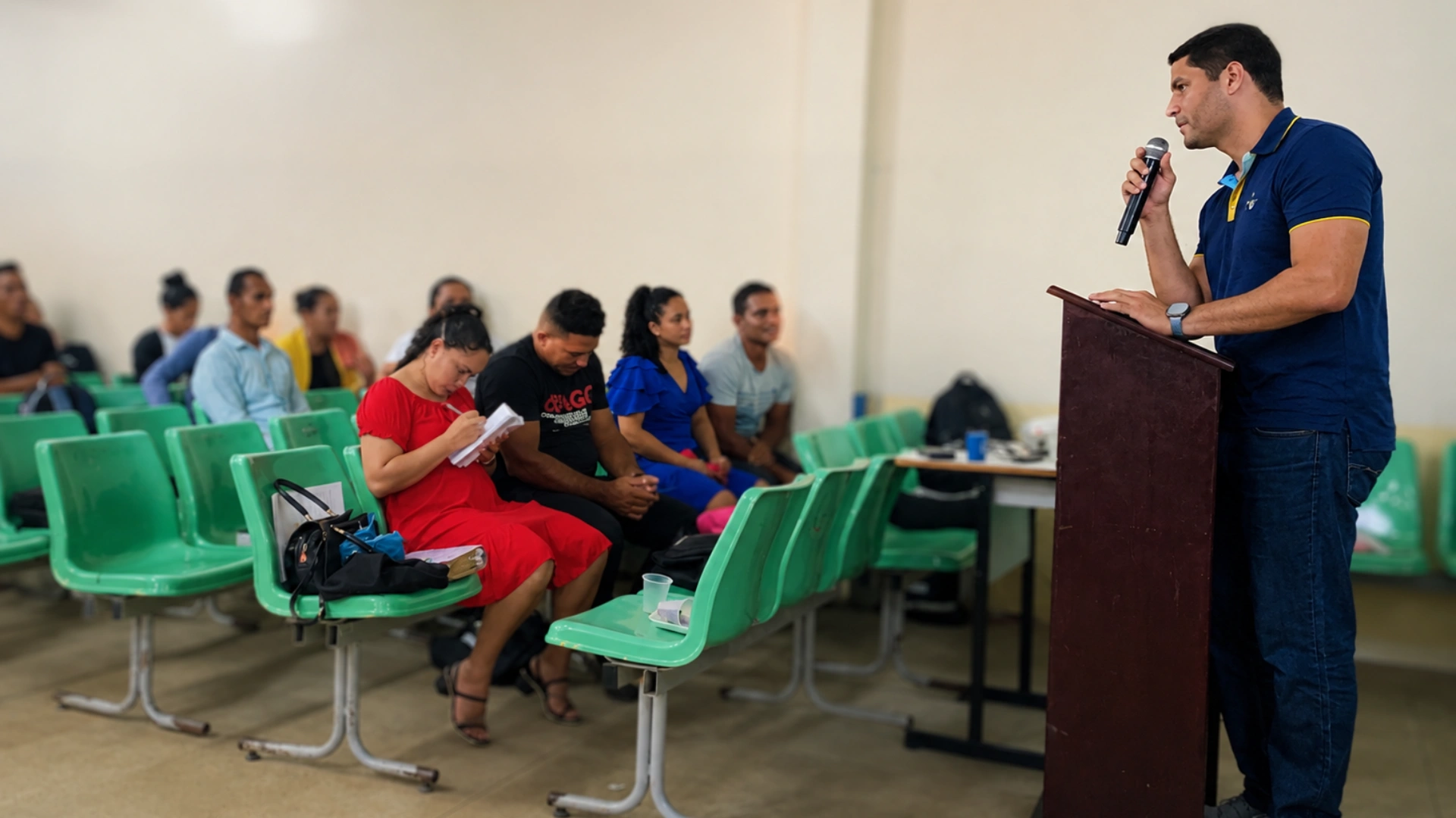 Público de jovens acompanhando uma capacitação em auditório ao ar livre